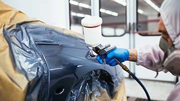 Person painting a car.